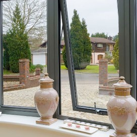A close up of partially opened bay windows looking out onto the forecourt