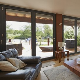 A view from the lounge, out through large bifold glass doors and over the river