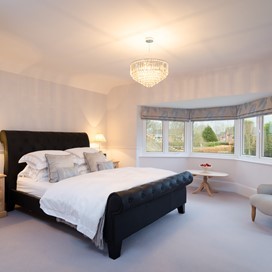 An internal shot of a bedroom with a bay window