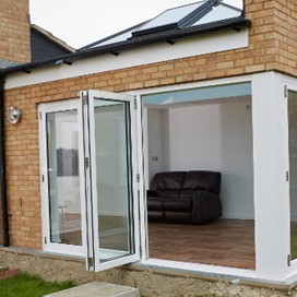 Looking into a garden room with large skylight through a partially opened folding door
