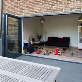 Folding doors pulled wide open providing a glimpse of a room with gym equipment and children's toys