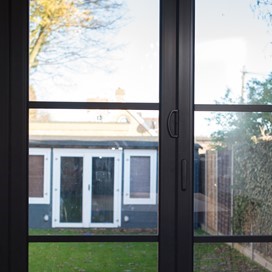Closed bifold doors looking through to a back building