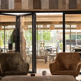 Open bifold doors leading out into the garden and outdoor section of the cafe