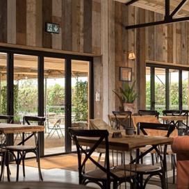 Dining hall looking out onto a farm through bifold doors 