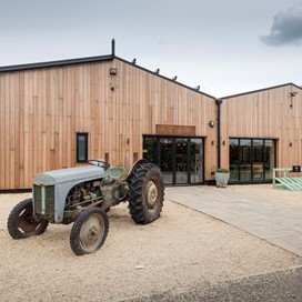 Outdoor of a farm shop with a blue tractor parked outside