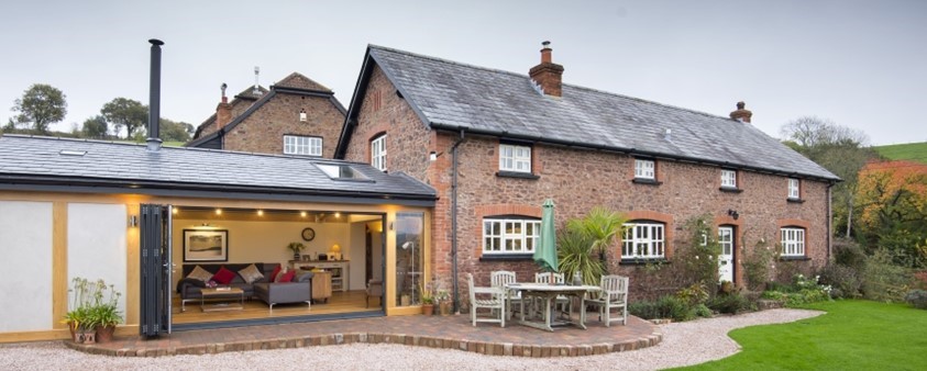An external view of Origin's windows and doors on an extension to a converted barn, shown here fully opened