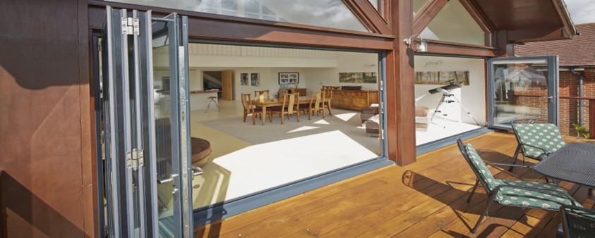 Looking into a modern stylish riverside property with the bifold doors fully opened