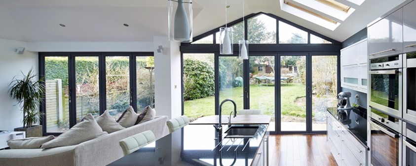 A large, bright, open plan kitchen and living area with large glass folding doors leading out to the garden