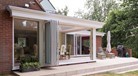 White bifold doors open from the outside revealing a set of table and chairs