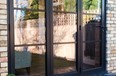Black bifold doors reflecting the image of a outdoor garden back at the camera