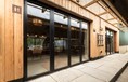 Black bifold doors closed from the outside looking into the dining hall 